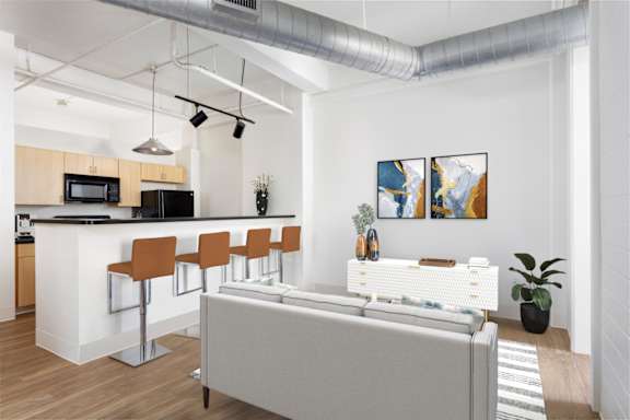 A modern kitchen with a white island and brown bar stools.