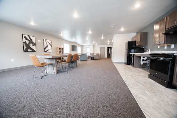 A spacious kitchen and dining area with modern furniture and appliances.