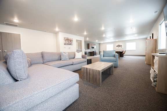 A living room with a grey couch and a wooden coffee table.