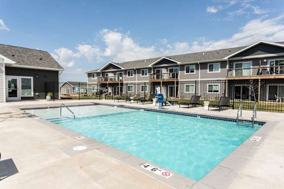 A swimming pool in front of apartment buildings.