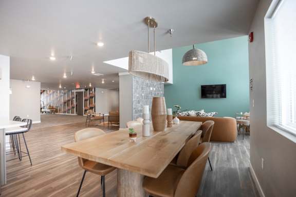 A modern dining room with a wooden table and chairs.