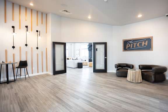 A room with a wooden floor and a sign that says "The Pitch".