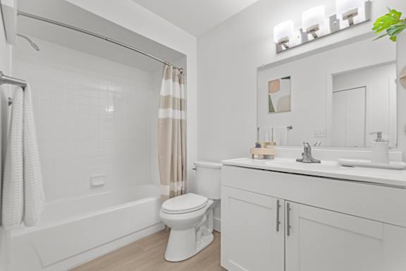 A white bathroom with a toilet, sink, and bathtub.