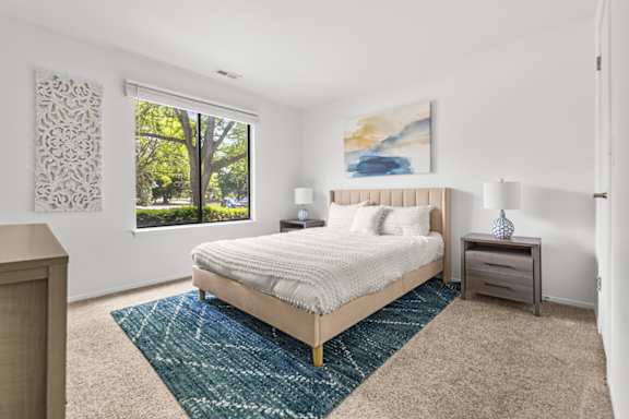 A bedroom with a large bed and a painting on the wall.
