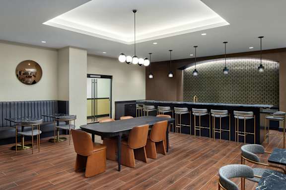 A modern dining room with a dark wood table and chairs.