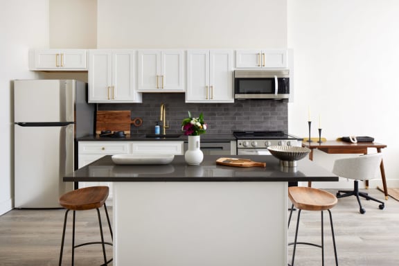 a kitchen with white cabinets and a black counter top