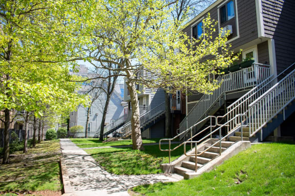 a sidewalk in front of a row of houses with stairs