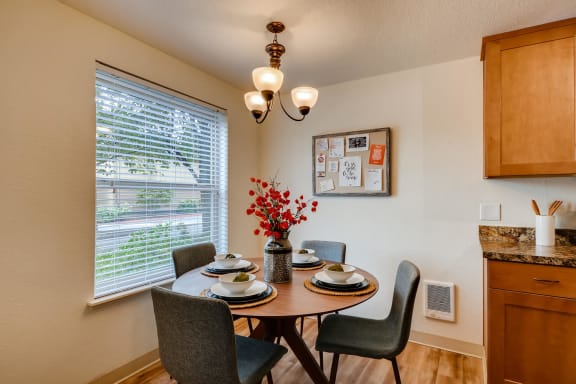 Apartments near Happy Valley for Rent - Sunnyside Village - Dining Room off of Kitchen with Large Window, White Walls, and Wood Flooring