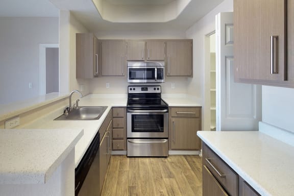 Kitchen with stainless steel microwave above matching oven, modern fixtures on cabinet fronts
