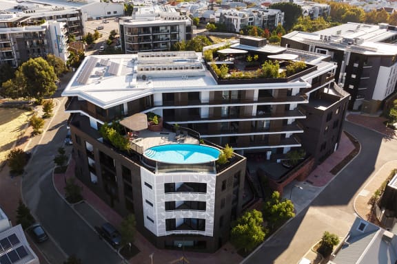 an aerial view of a building with a swimming pool on top of it