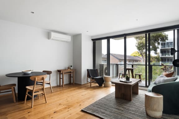 a living room with a couch and a table and a balcony