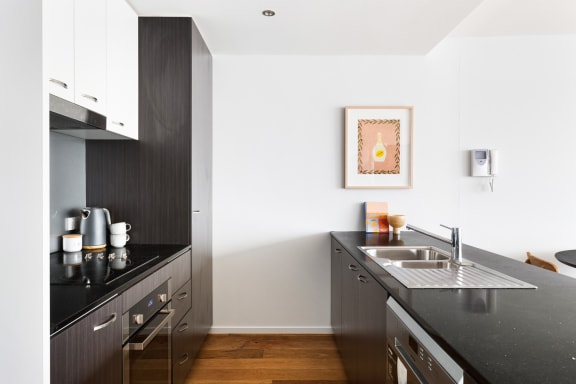 a kitchen with black countertops and a sink and a window