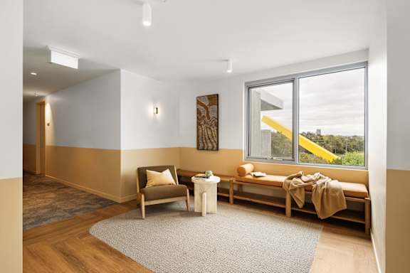 a living room with a window and a chair and a table