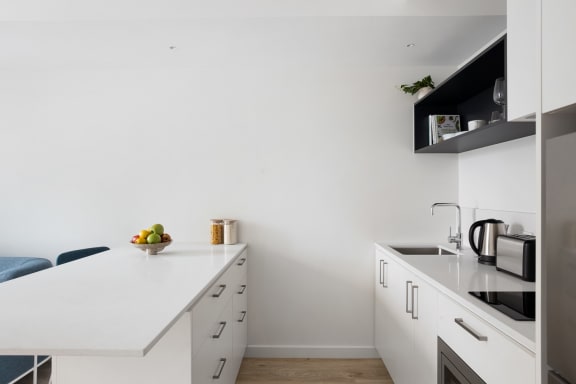 a kitchen with a white counter top and a sink