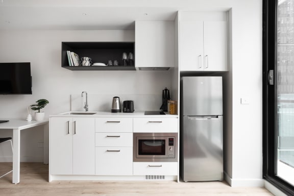 a kitchen with white cabinets and a stainless steel refrigerator