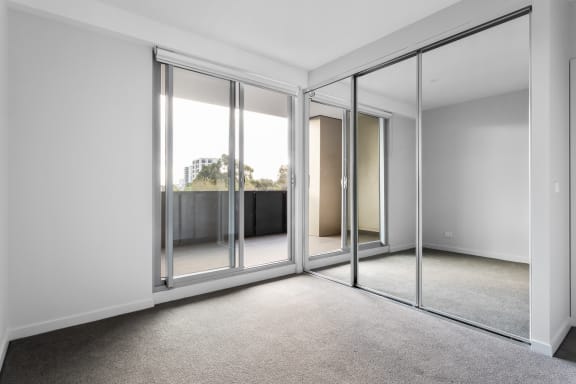 an empty living room with glass sliding doors