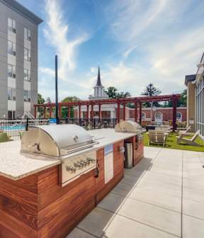 an outdoor patio with a grill and a table with chairs