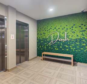 an elevator lobby with a green wall with the name of the company on it