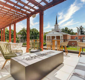 a patio with a table and chairs and a church in the background