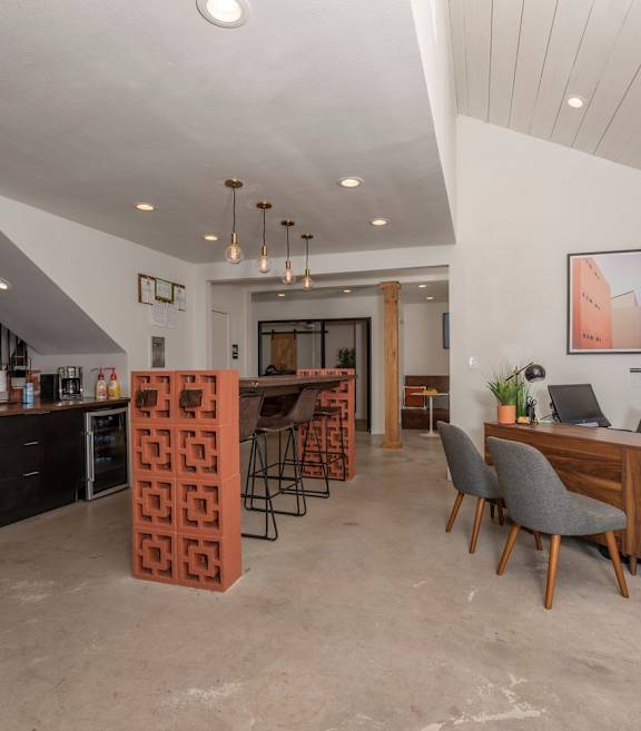 Fusion 35 leasing office with an orange table, grey chairs, and a coffee bar.