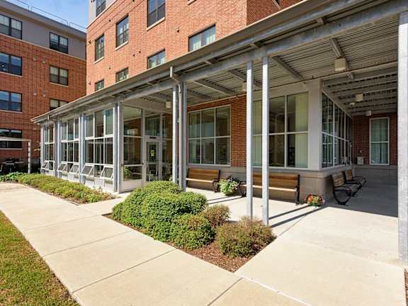 A building with a covered walkway and benches.