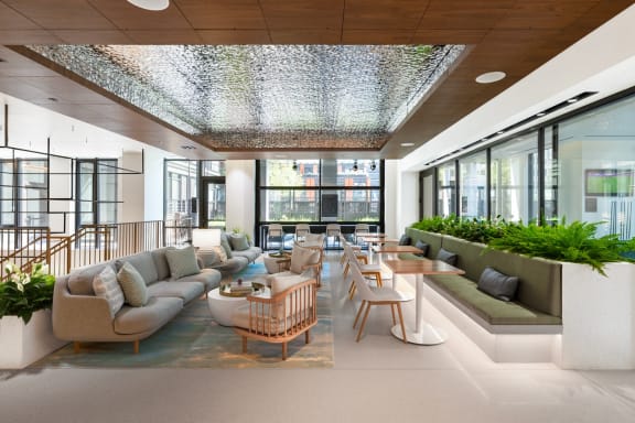 a lobby with couches tables and chairs and windows