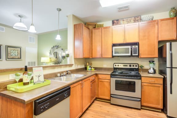 a large kitchen with wooden cabinets and stainless steel appliances
