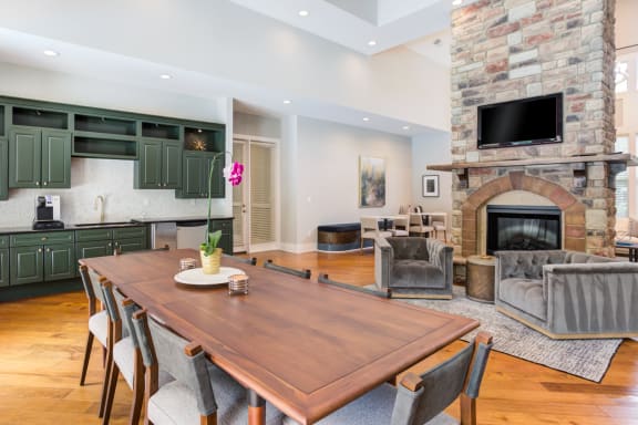 a dining room with a wooden table and a stone fireplace