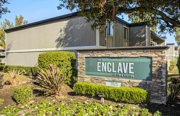 the enclave at titzer station sign in front of building
