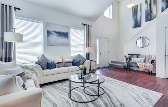 a living room with white furniture and a white rug