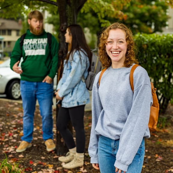 a group of people standing in front of a tree