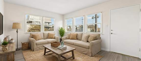 A living room with a brown rug and a wooden coffee table.