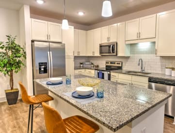 a kitchen with white cabinets and a granite counter top
