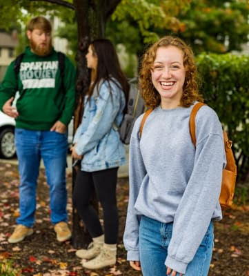 a group of people standing in front of a tree