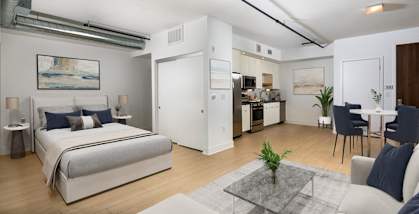 a bedroom with a bed and a living room with a kitchen  at The LC, Los Angeles