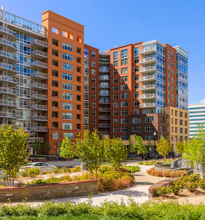 a group of apartment buildings in a park with trees