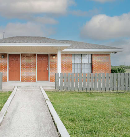 a house with red doors and a white picket fence