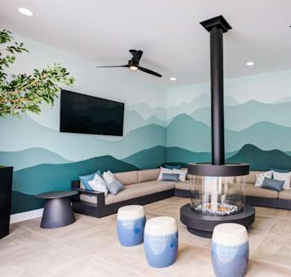 A living room with a television, a sofa, and a fireplace at Pradera Apartments, San Ramon, 94582