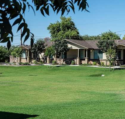 A row of houses with a green lawn in front.