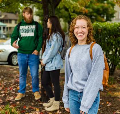 a group of people standing in front of a tree