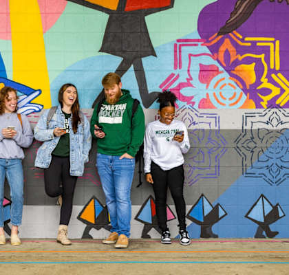 people standing in front of a wall with their cell phones