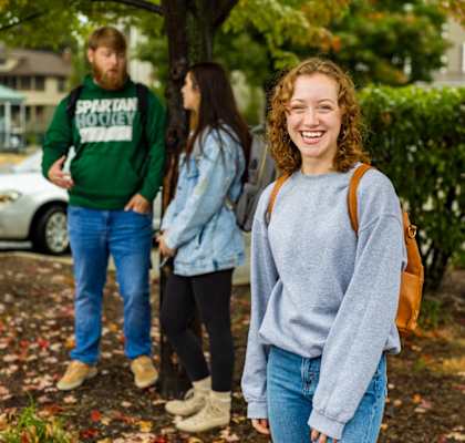 a group of people walking down a sidewalk on a college campus
