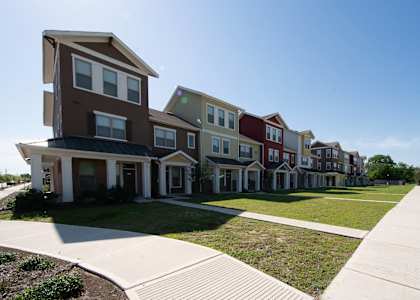 a row of townhomes with a sidewalk in front of them