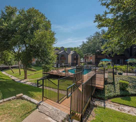 A backyard with a pool and a deck.