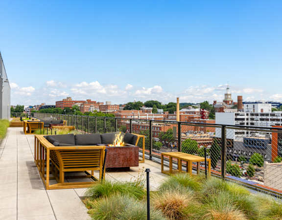 a roof terrace with furniture and a city in the background