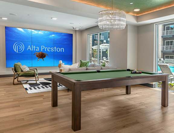A pool table in a room with a sign that says Alta Preston.