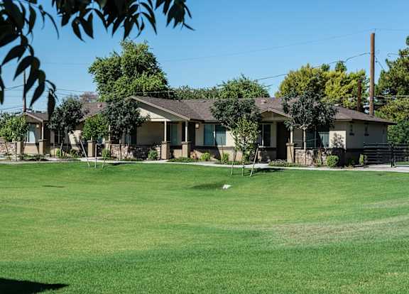 A row of houses with a green lawn in front.