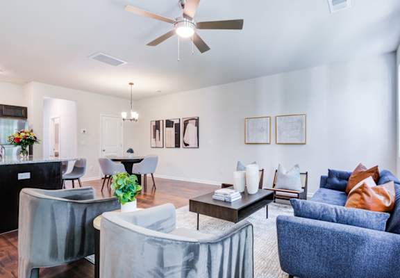 a living room with a ceiling fan and couches