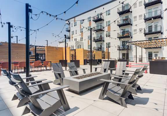 a patio with chairs and a firepit at the axis at walnut creek apartments