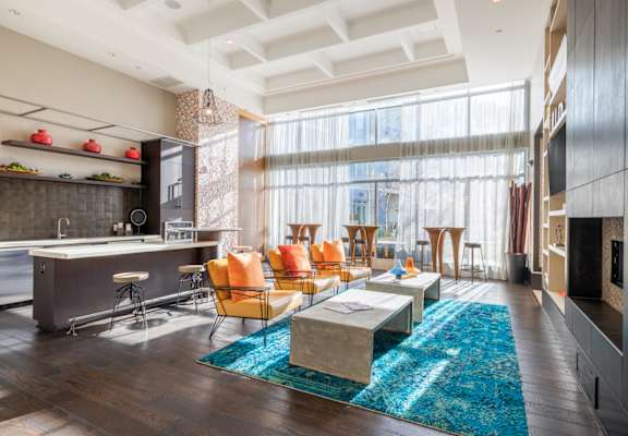 A modern kitchen with a bar area and a dining table with chairs. at Indigo 301, King of Prussia
